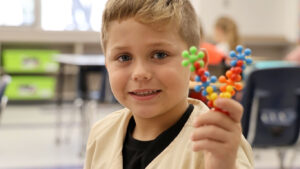 Child holding toy molocule