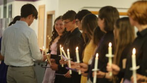 National Honor Society inductees hold lighted candles during their induction ceremony