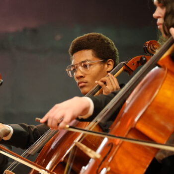 A student plays the cello during his symphony concert.