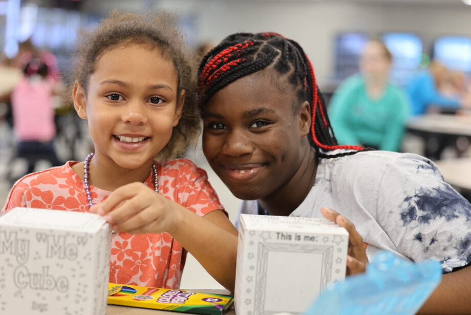 A high school mentor and her elementary age mentee pose for a photo during their first Club M meeting of the school year.