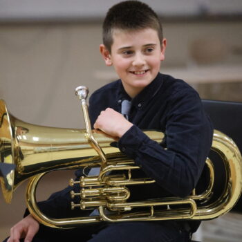 A boy smiles while holding a baritone ahead of his Solo Fest performance.