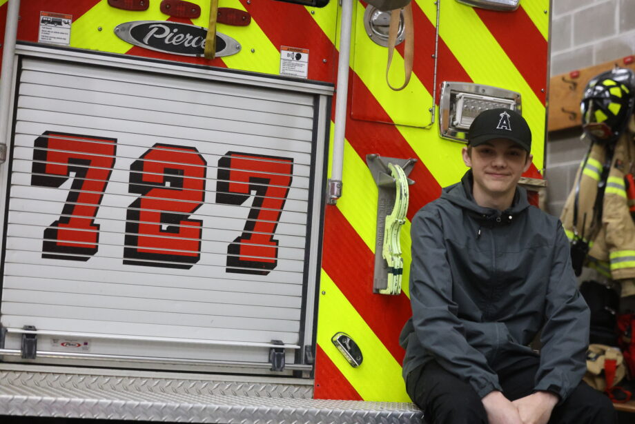 Christian Teeter, a 14-year-old eighth grade student at Edward Stone Middle School, sits on the back of Engine 727 April 26 at the Burlington Fire Department just before leaving on a call.