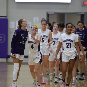 Members of the girls basketball team celebrate at the close of a winning game.