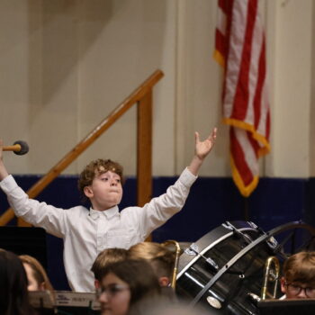 A student holds up his hands while holding a drum mallet ahead of a concert at Memorial Auditorium.