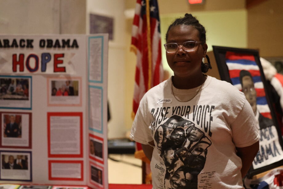 Sixth-grader Jamiyah Davenport stands alongside an exhibit on President Barack Obama Feb. 28, 2024, during Aldo Leopold Intermediate School's third annual Black History Museum.