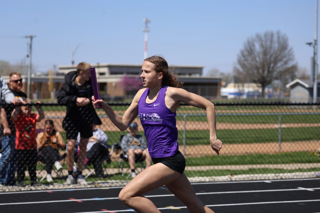 A member of the girls track and field team runs on the track