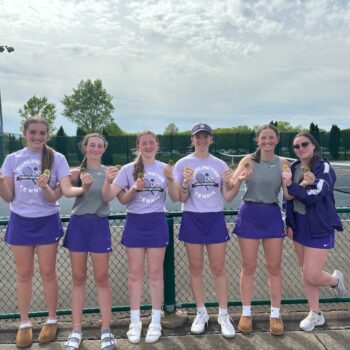 Members of the BHS girls tennis team smile while holding up medals they earned during the Southeast Conference Tournament.