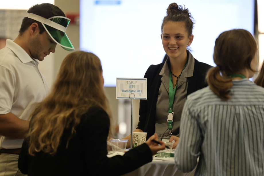 Burlington High School students Kingsley Miller, Lily Newell and Shannan Skeens discuss strategy Wednesday, Oct. 11, during the Junior Achievers Stock Market Challenge at St. Ambrose University in Davenport.