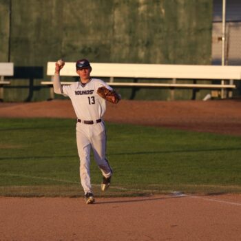 A baseball player holds a ball in his hand before throwing it.