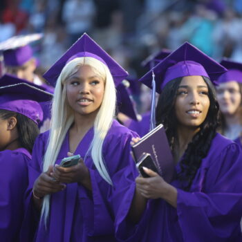 A group of graduates stand up before turning their tassels during the 2024 Commencement Ceremony at Bracewell Stadium.