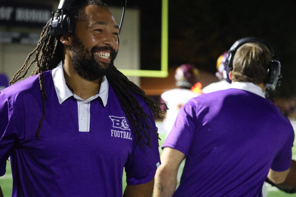 Head football coach Jordan Webb, a 2011 graduate of BHS, smiles after the Grayhounds score a touchdown against Mount Pleasant during the Homecoming game.  