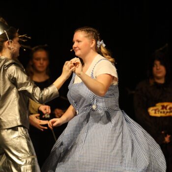 Dorothy and the Tinman dance during a high school musical production of 