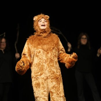 The Cowardly Lion sings on stage during the high school musical production of 