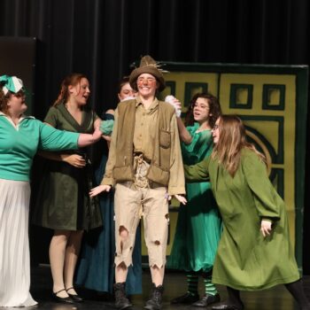 Scarecrow is surrounded by Oz residents while onstage during the high school musical production of 