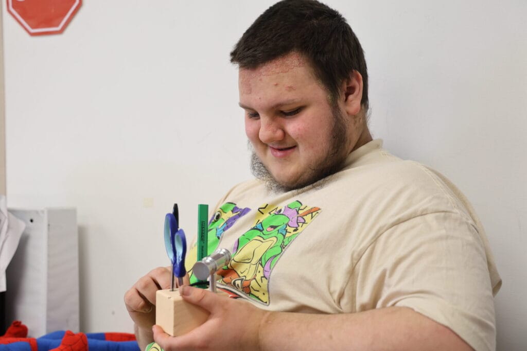 Burlington High School junior Carson Sutton holds a pencil holder Wednesday, Feb. 26, 2025, in his classroom at Burlington High School. Sutton and his classmates made pencil holders in their Adaptive Industrial Technology class.