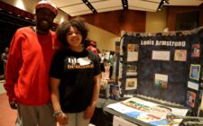 Demond Carr and his daughter, fifth-grader Journey Carr, pose for a photo alongside an exhibit about Louis Armstrong Thursday, Feb. 17, 2025, during Aldo Leopold Intermediate School’s fourth annual Black History Museum. The exhibit was one of more than 20 student-led projects on display.